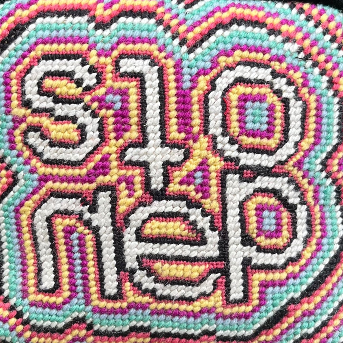 psychedelic, colorful pattern with the word stoned in the center