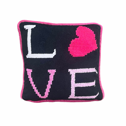 black velvet pillow with pink letters reading LOVE
