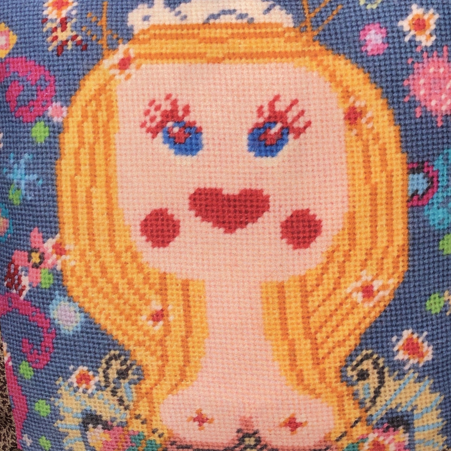 blonde, blue-eyed girl with bird nest on top of head; whimsical colorful elements surround her; chimerical designer pillow
