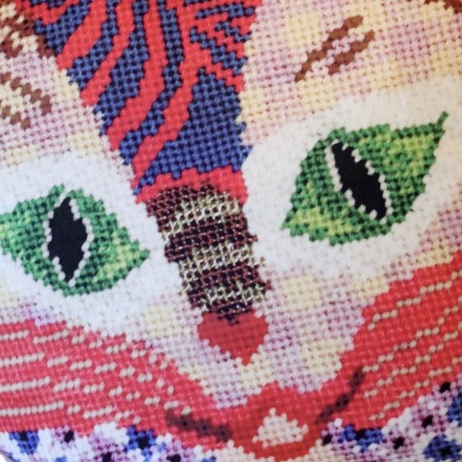 Multi-patterned sculpted cat in primarily pink and red colored with a checked face, swirls, leopard print , green eyes & flowers. Kitty Love is written on the ears.
