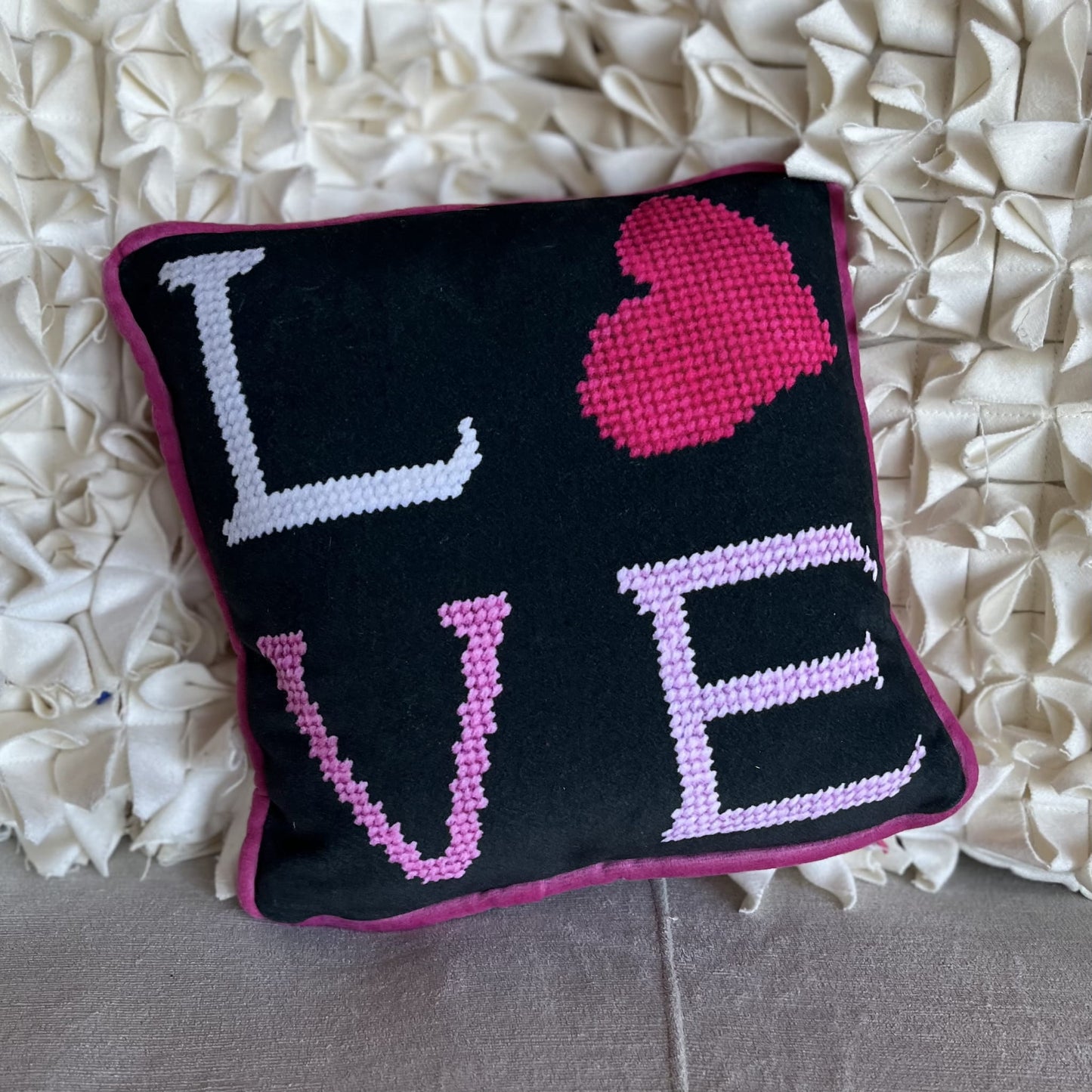 black velvet pillow with pink letters reading LOVE