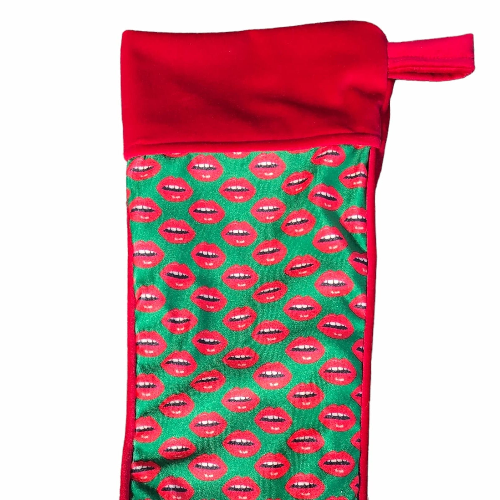 velvet holiday stocking covered in red lips with red cuff and hook, Christmas green background