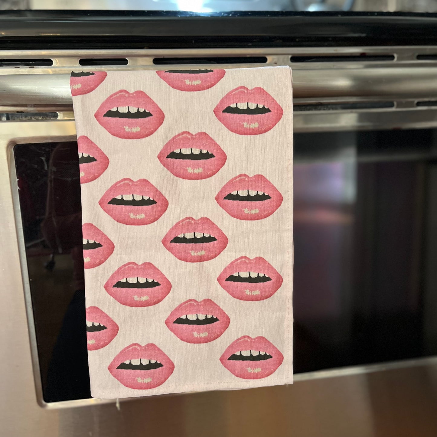 linen-colored tea towel with soft pink lips covered all over it