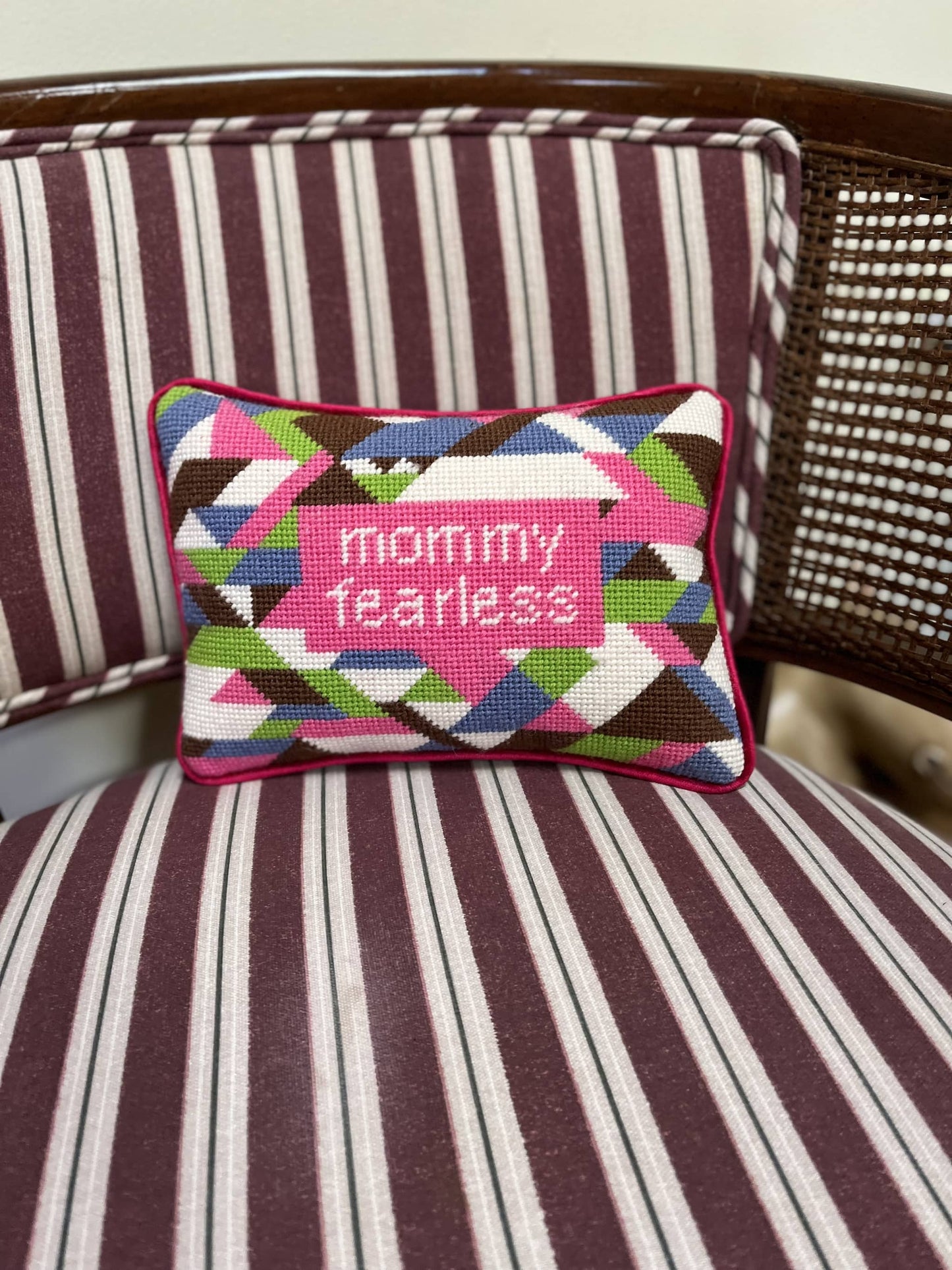 needlepoint MOMMY FEARLESS in hot pink box centered on pillow, surrounded by purple, lime, white & brown geometrics