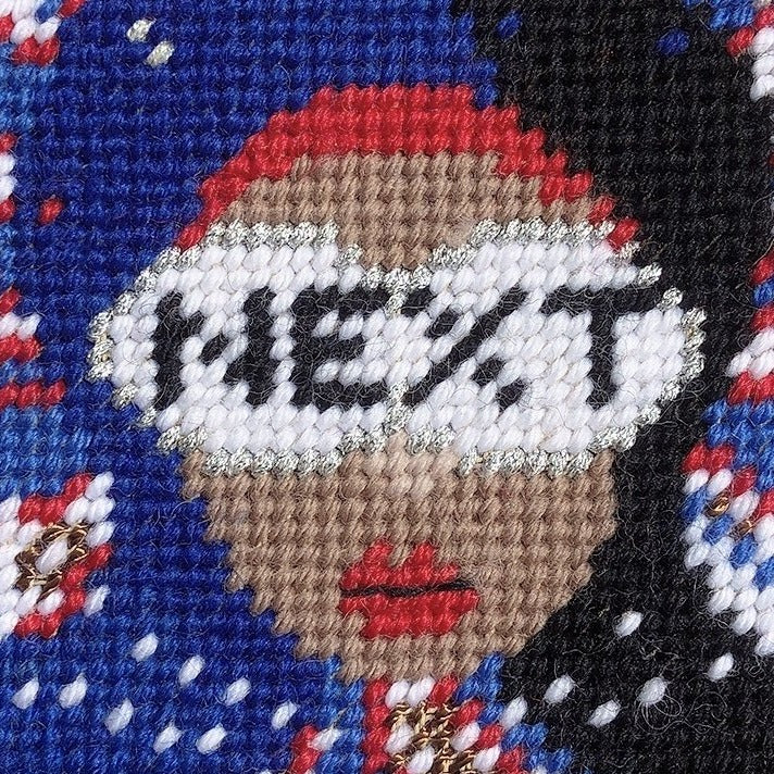 red, white & blue pillow with lady centered, flipped black hair, pearl necklace and sunglasses that say NEXT