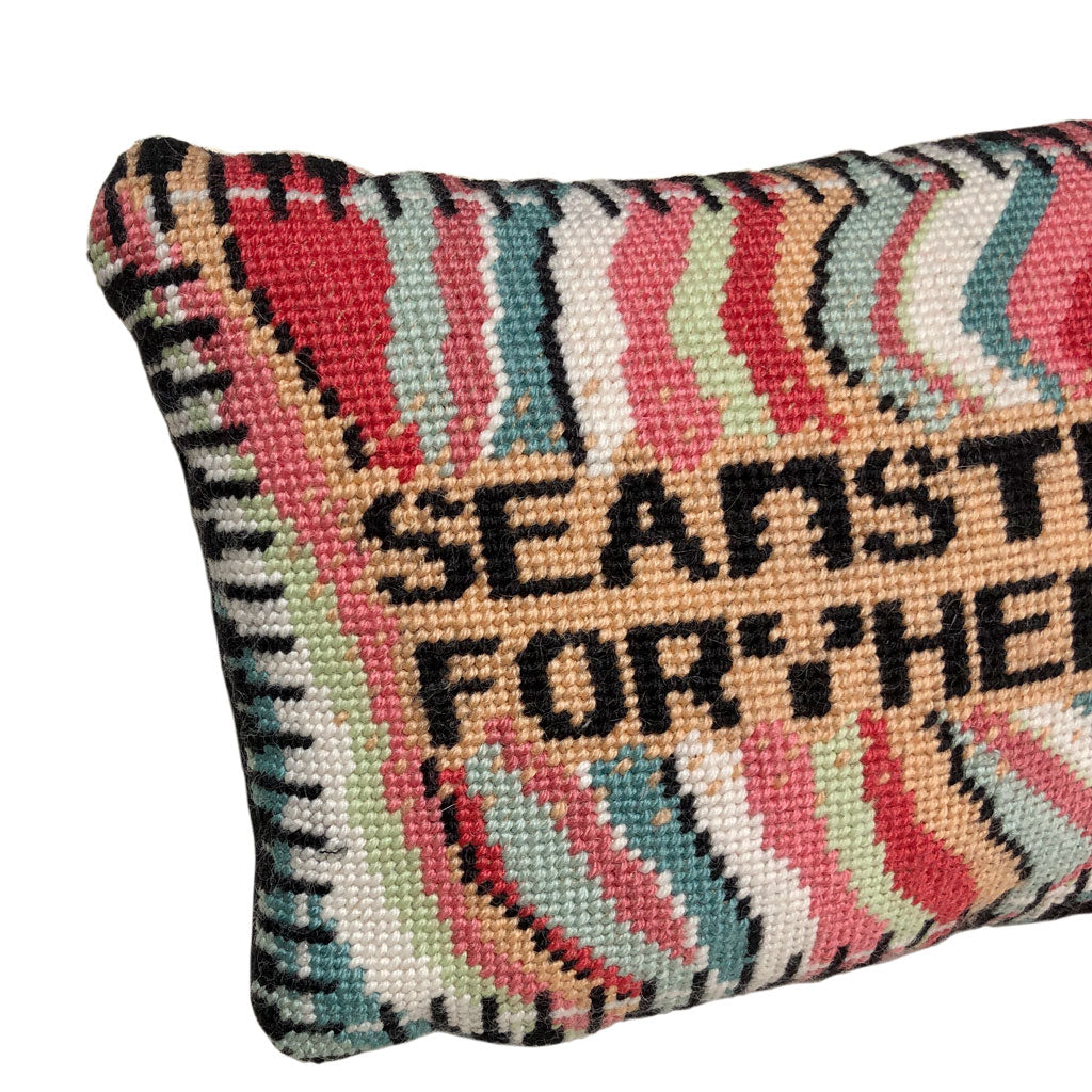 SEAMSTRESS FOR THE BAND stitched in black inside tan box, surrounded by wavy bands of turquoise, pink, red, white, lime and a keyboard border