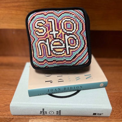 objet d'art pillow features psychedelic, colorful pattern with the word stoned in the center