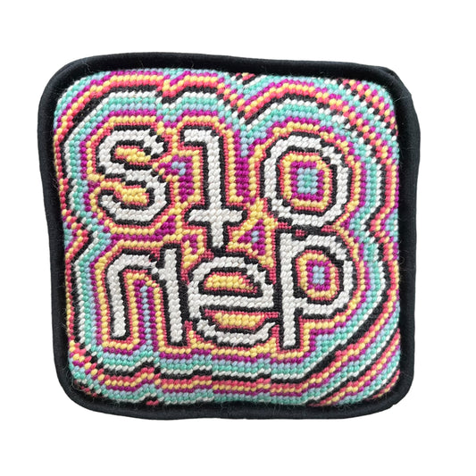 objet d'art pillow features psychedelic, colorful pattern with the word stoned in the center