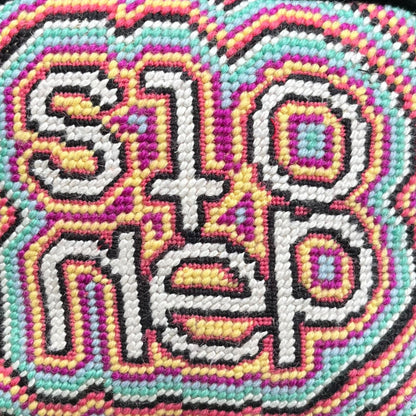 objet d'art pillow features psychedelic, colorful pattern with the word stoned in the center