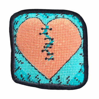 Variegated orange broken-heart pillow with turquoise background