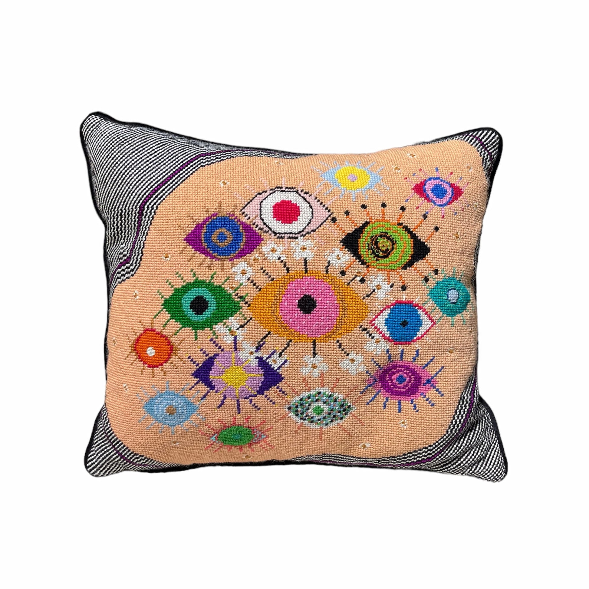 hand-embroidered lyrical pillow is covered in whimsical eyes of varying colors; vertigo band white swirl border