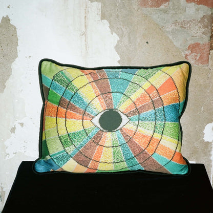 pillow has eye centered design with variegated rays of color - turquoise, green, brown, orange, yellow