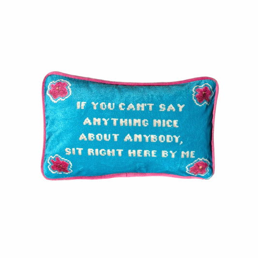 "If you can't say anything nice about anybody, sit right here by my" pillow with pink flowers in the corners and turquoise background.
