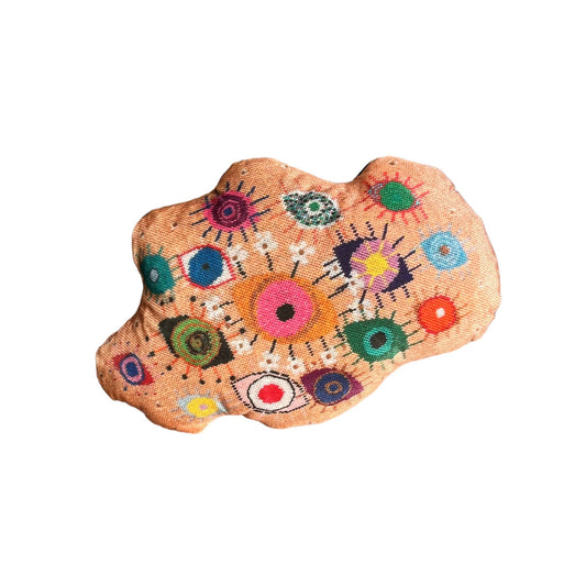 velvet amoeba-shaped pillow covered in fanciful, brightly-colored-eyes