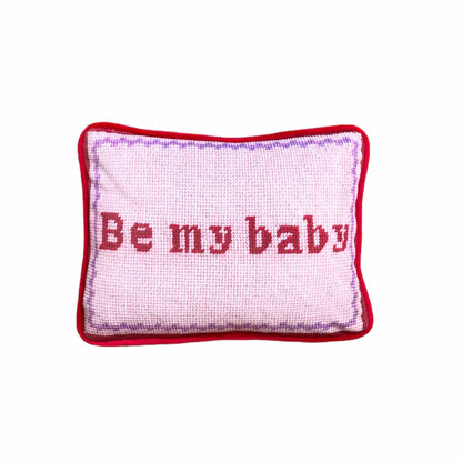 Pink velvet pillow with red letters that say "Be My Baby"; lavender wavy border.