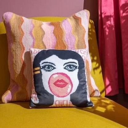 velvet pillow of doe-eyed girl with Jackie O hair and yellow hair clamp, blowing a bubble