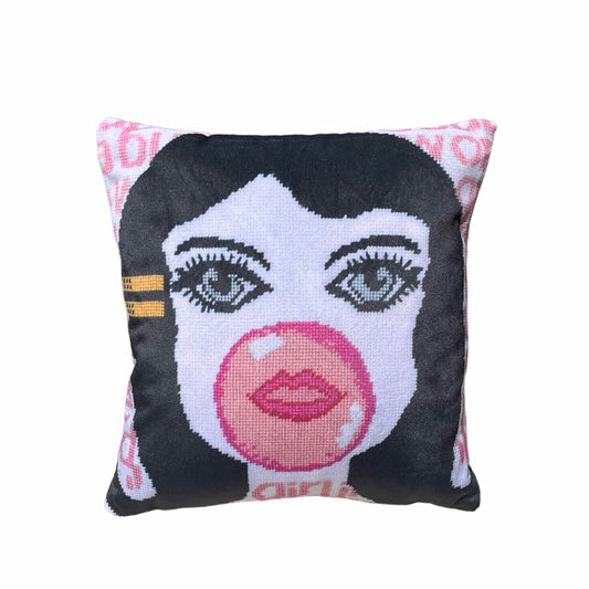 velvet pillow of doe-eyed girl with Jackie O hair and yellow hair clamp, blowing a bubble
