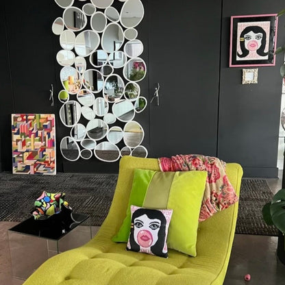 velvet pillow of doe-eyed girl with Jackie O hair and yellow hair clamp, blowing a bubble