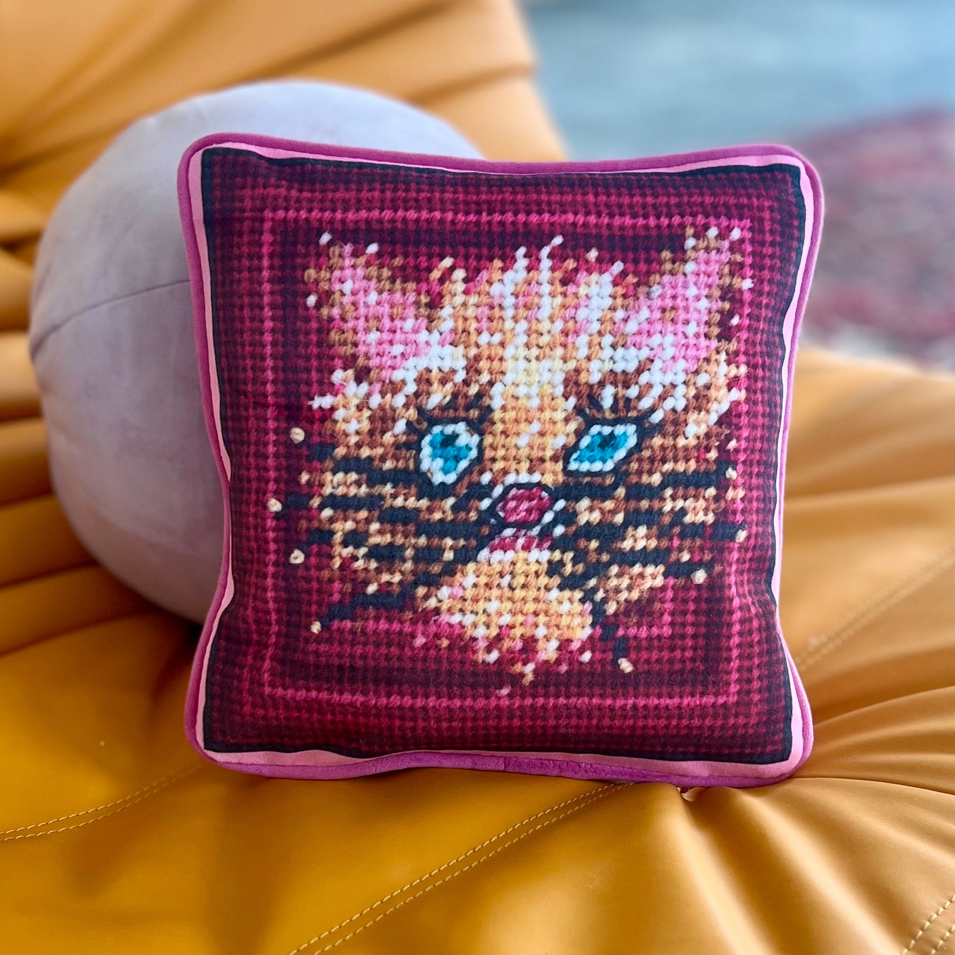 wild blue eyed cat in whimsical gold and pink with pinkish frame