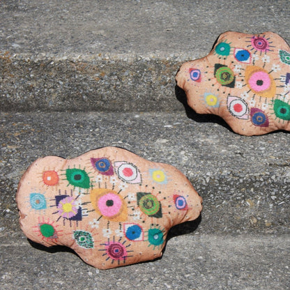 velvet amoeba-shaped pillow covered in fanciful, brightly-colored-eyes