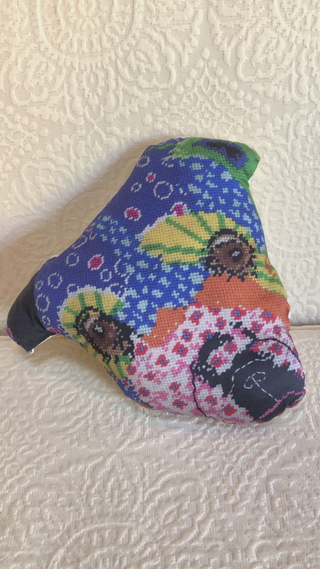 whimsical dog pillow with brown starry eyes, pink flowers, purple dots, pink flowers