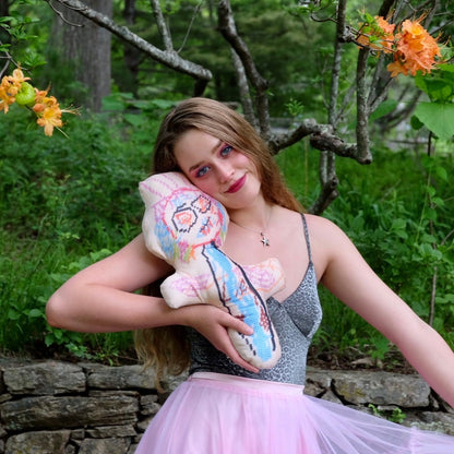 blonde model with sculpted, colorful abstract monster with big eyes & wild hair