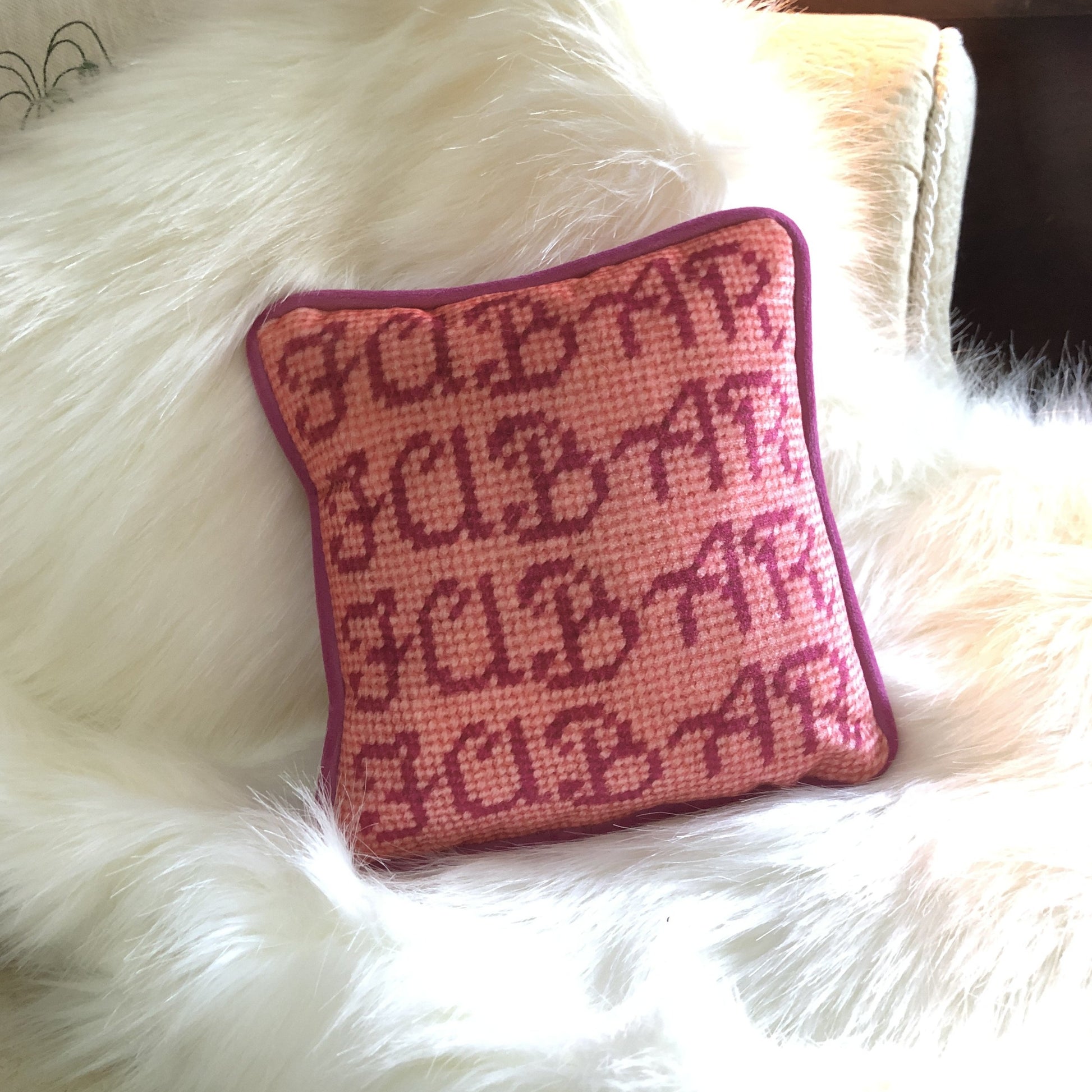 hot pink FUBAR written four times and stacked on top of each other; pink background on white faux fur throw