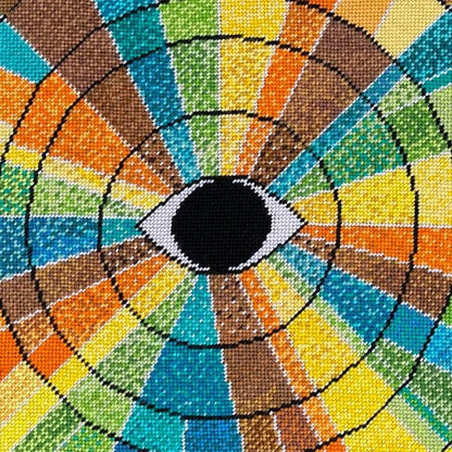 pillow has eye centered design with variegated rays of color - turquoise, green, brown, orange, yellow