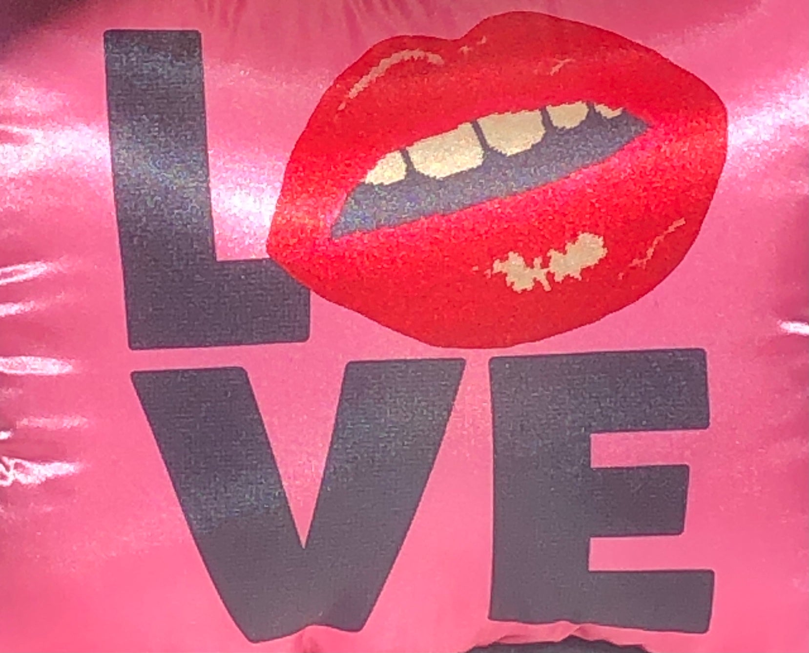hot pink pillow with blackletters - L, red lips for an O, V & E stacked underneath