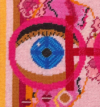 needlepoint pillow with pink and red colorful pattern, blue eye, cheetah, heart snakes, roses and lettering OOH in center with a LA LA LA border