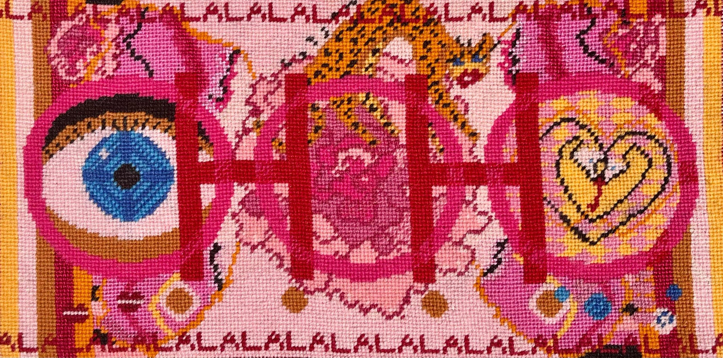 needlepoint pillow with pink and red colorful pattern, blue eye, cheetah, heart snakes, roses and lettering OOH in center with a LA LA LA border