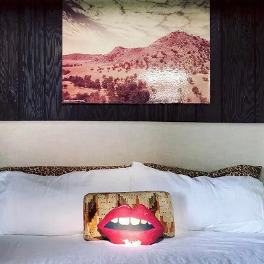 sculpted red lips pillow shown on contemporary bed