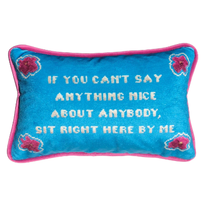"If you can't say anything nice about anybody, sit right here by my" pillow with pink flowers in the corners and turquoise background.