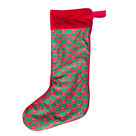 velvet holiday stocking covered in red lips with red cuff and hook, Christmas green background