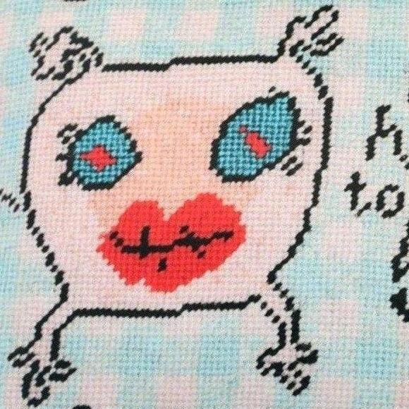 sweet monster pillow with big blue eyes & big red lips on baby blue checked background; says It's so hard to be a baby.
