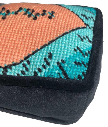 Variegated orange broken-heart pillow with turquoise background. Hand embroidered, one of a kind.