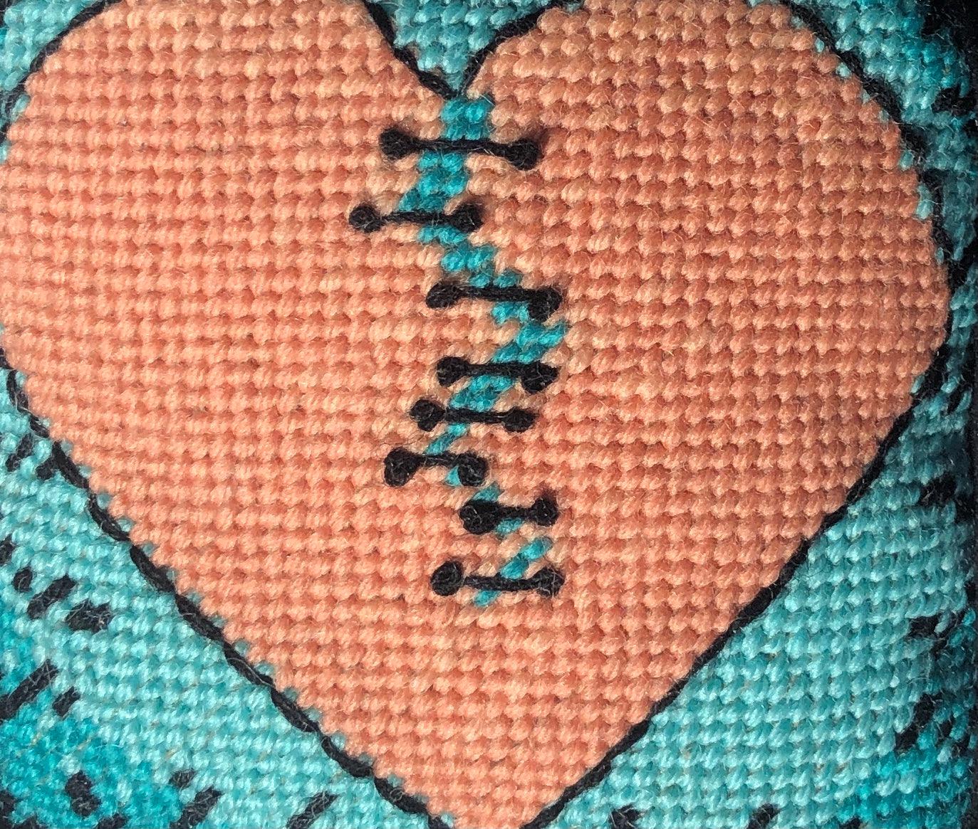 Variegated orange broken-heart pillow with turquoise background. Hand embroidered, one of a kind.