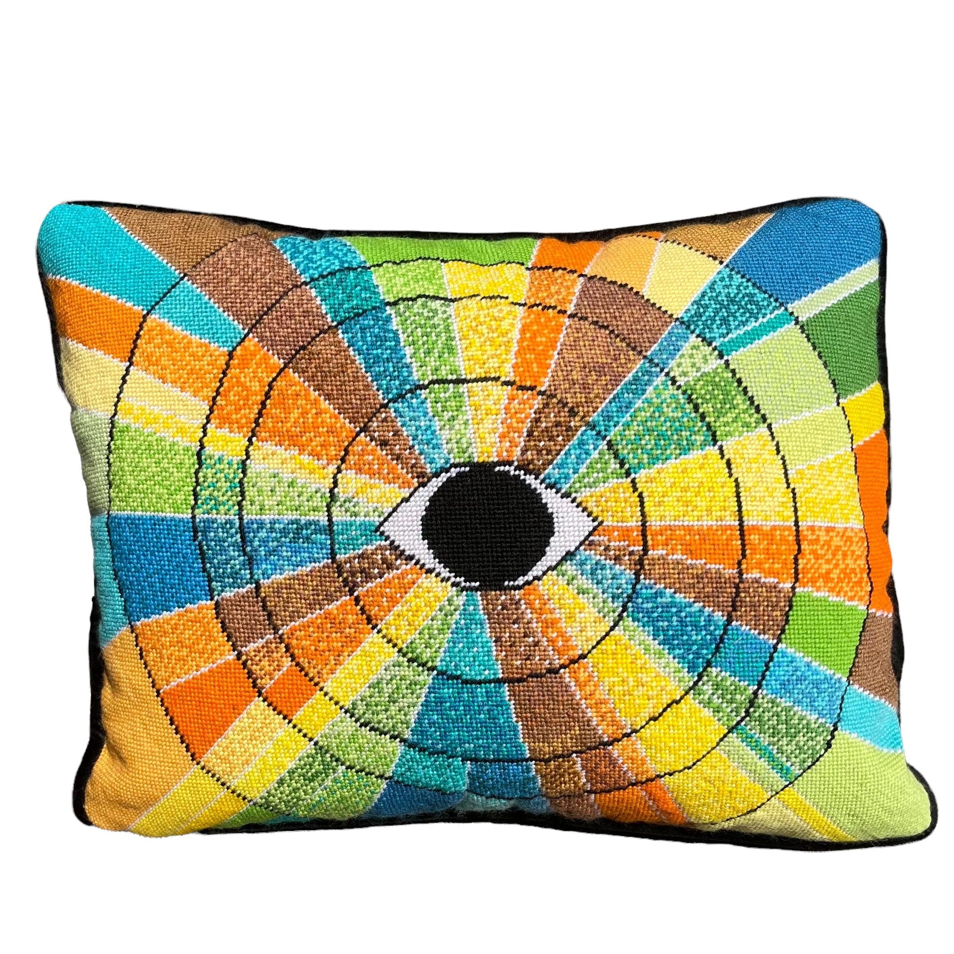 pillow has eye centered design with variegated rays of color - turquoise, green, brown, orange, yellow
