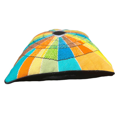 pillow has eye centered design with variegated rays of color - turquoise, green, brown, orange, yellow