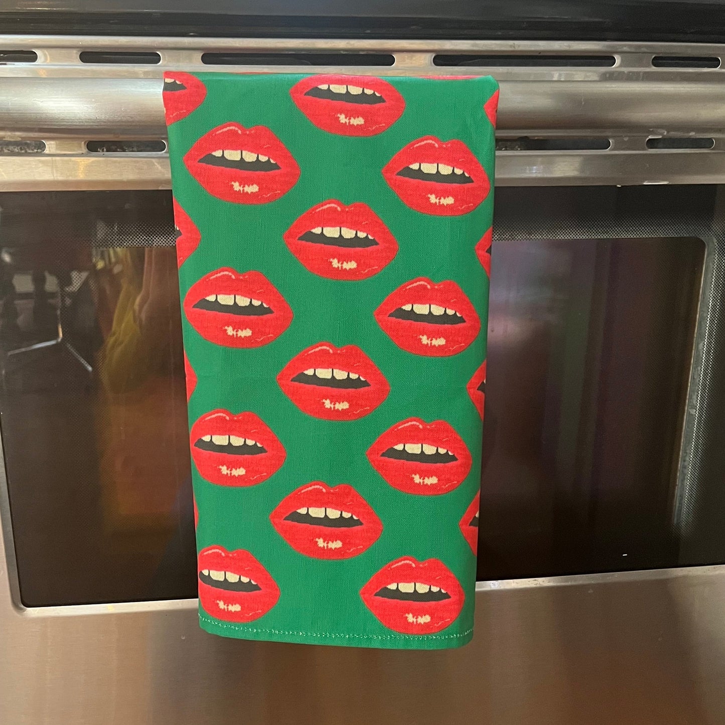 Christmas green tea towel covered in red lips