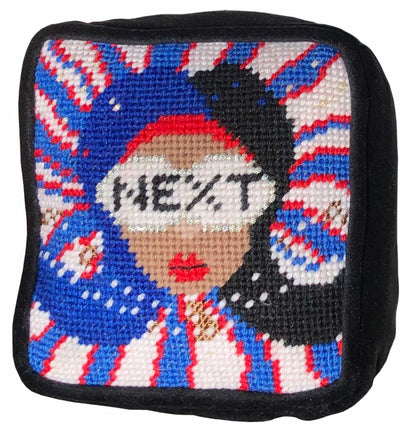 needlepoint red, white & blue pillow with lady centered, flipped black hair, pearl necklace and sunglasses that say NEXT