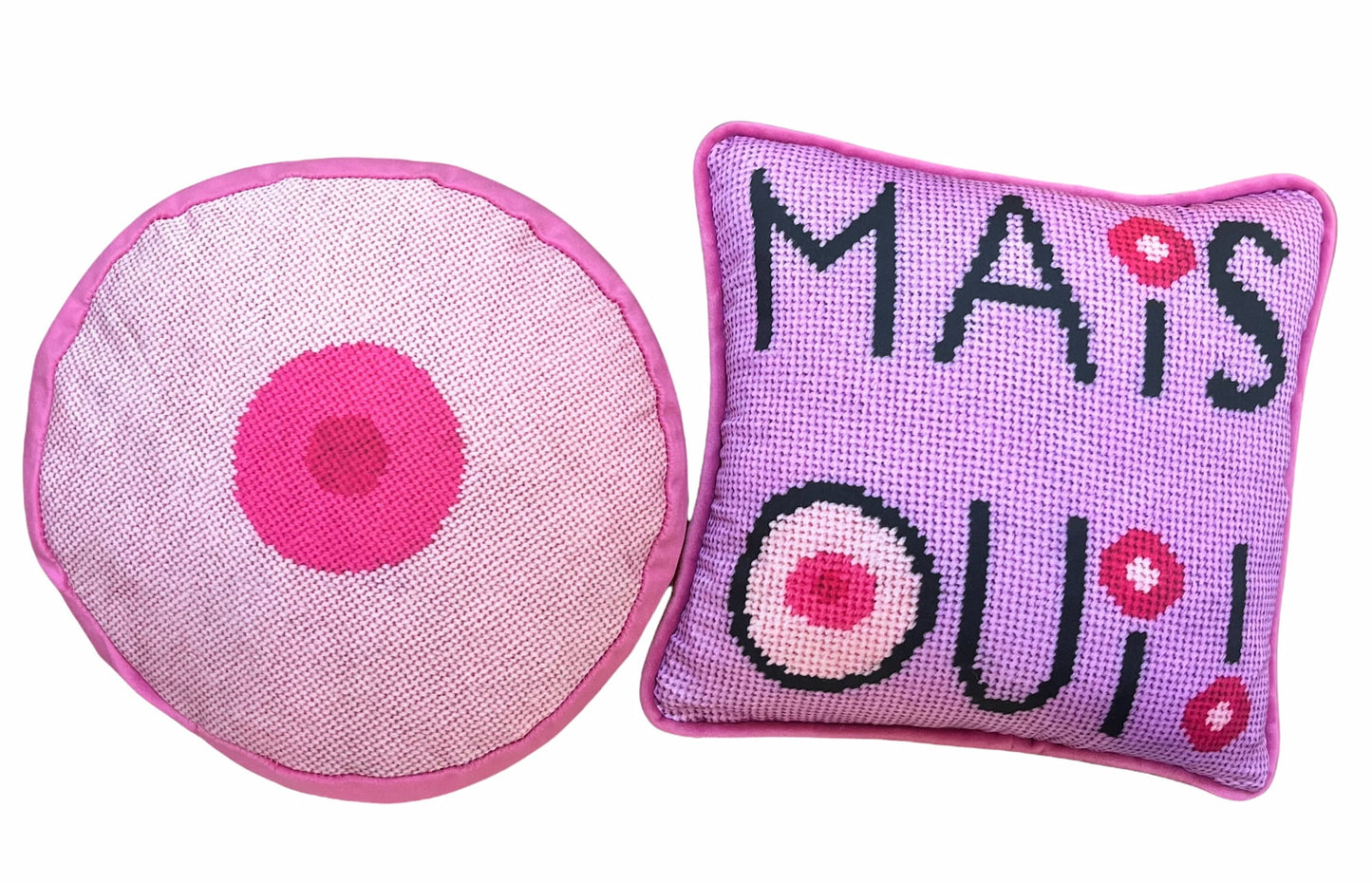  baby pink round pillow with hot pink small center and square  mais oui black stacked text with I dot and O that have cream colored centers with pink circles. Lavender pink background.
