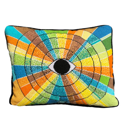 pillow has eye centered design with variegated rays of color - turquoise, green, brown, orange, yellow