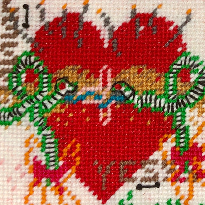 needlepoint kissing snakes on a heart