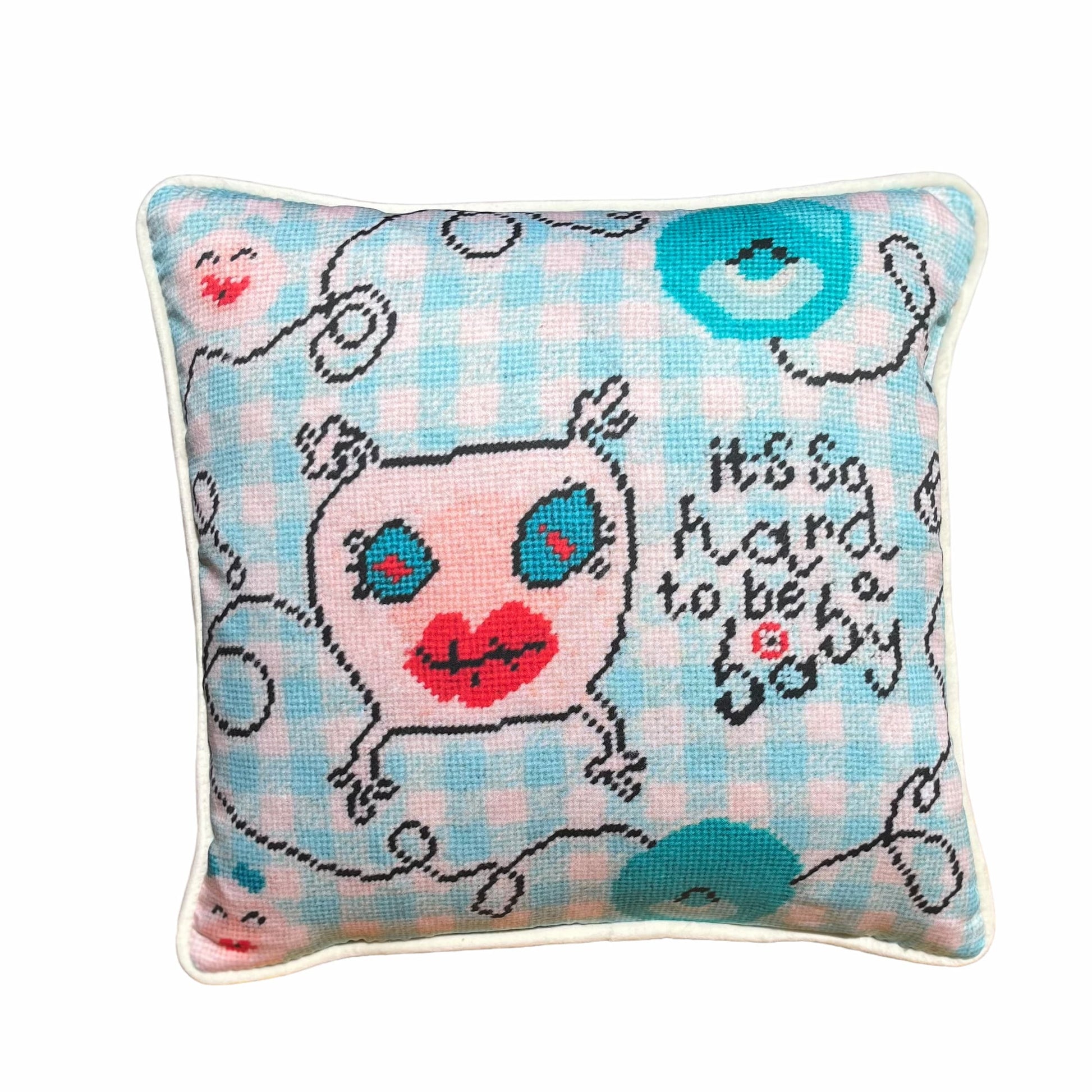 sweet monster pillow with big blue eyes & big red lips on baby blue checked background; says It's so hard to be a baby