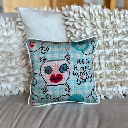 sweet monster pillow with big blue eyes & big red lips on baby blue checked background; says It's so hard to be a baby