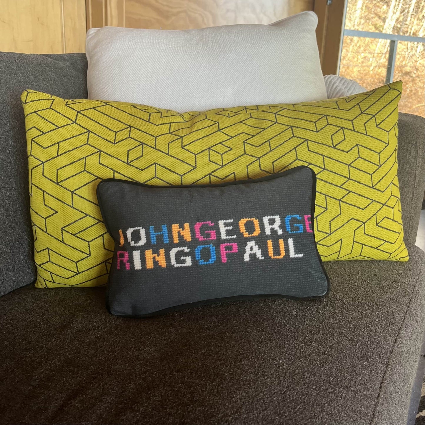 JOHNGEORGE on top line; RINGOPAUL written in colorful yellow, white, blue and pink letters on solid black background. The Beatles pillow.