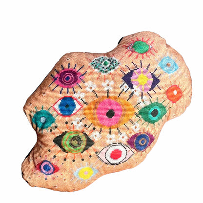 velvet amoeba-shaped pillow covered in fanciful, brightly-colored-eyes