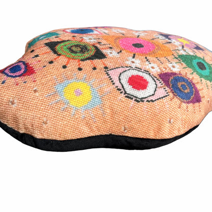 velvet amoeba-shaped pillow covered in fanciful, brightly-colored-eyes