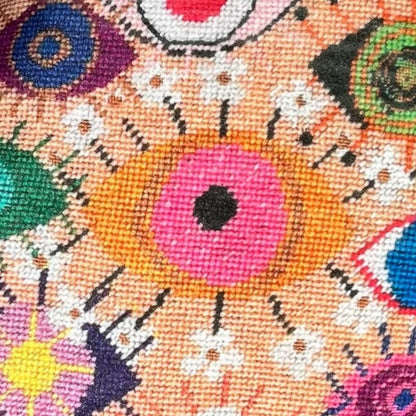 velvet amoeba-shaped pillow covered in fanciful, brightly-colored-eyes